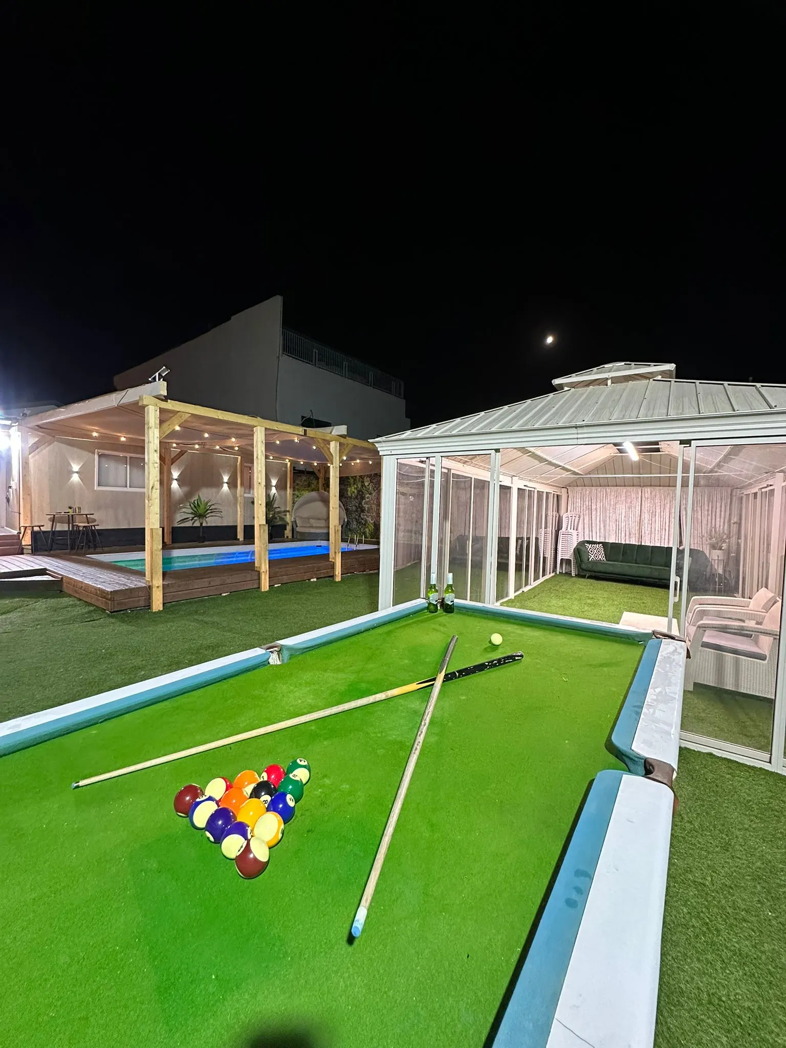 מבט לילי רחב על המתחם: סנוקר, בריכה מוארת והגזיבו